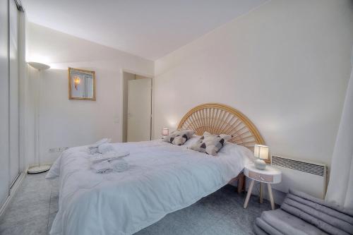 une chambre blanche avec un grand lit blanc avec des oreillers dans l'établissement Super Central Cannes - all comfort - Calm, à Cannes