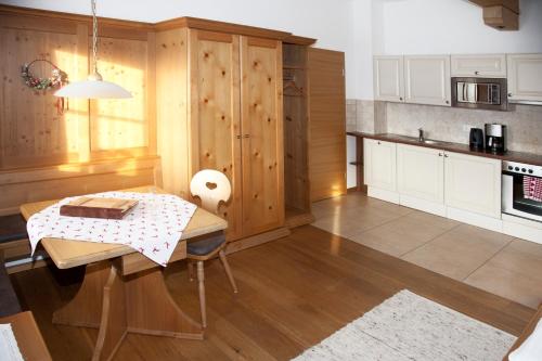 a kitchen with a wooden table and a tableasteryasteryasteryasteryasteryasteryastery at Filzenhof in Kitzbühel
