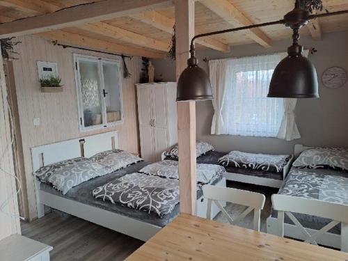 a bedroom with two beds and a table and chairs at NAD STARÝM SKLEPEM in Valtice