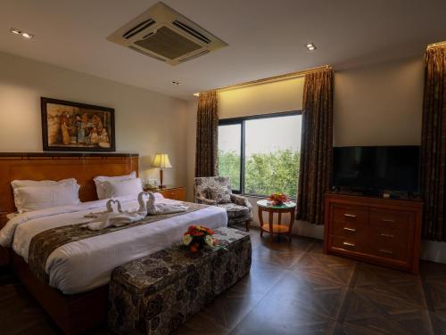 a hotel room with a bed and a television at The Greenwood - Tezpur in Tezpur