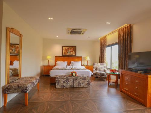 a hotel room with a bed and a television at The Greenwood, Tezpur in Tezpur