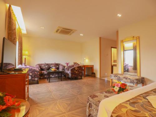 a hotel room with a bed and a living room at The Greenwood, Tezpur in Tezpur