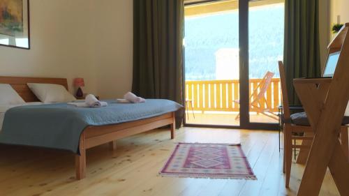 um quarto com uma cama e vista para uma varanda em Hotel Lamish em Mestia