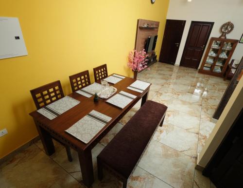 a dining room with a wooden table and chairs at AVANTI CASTELLO in Guruvāyūr