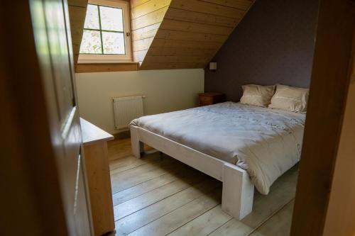 ein Schlafzimmer mit einem Bett im Dachgeschoss mit einem Fenster in der Unterkunft Bed and Breakfast Paellepelhoeve in Ninove