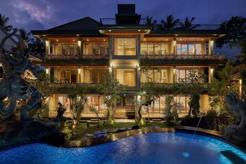 a large house with a swimming pool in front of it at Gynandha Ubud Cottage in Ubud