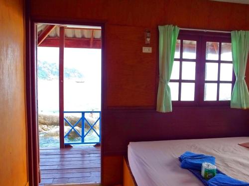 a bedroom with a bed and a window with a view at OK2 Mamajim Bungalows in Ko Tao