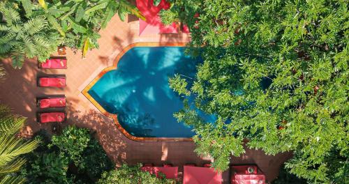 - une vue sur la piscine entre les arbres dans l'établissement Angkor Village Hotel, à Siem Reap