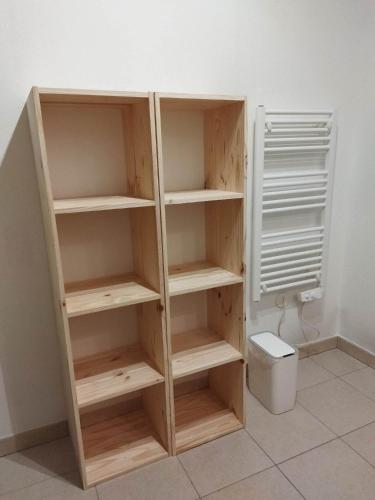 - une étagère en bois dans une salle de bains pourvue de toilettes dans l'établissement Chez Daniel, linge et ménage inclus, à Agde