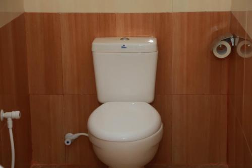 a white toilet in a bathroom with wooden walls at Hotel MOONSTONE in Anuradhapura