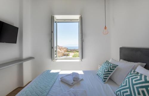 a bedroom with a bed with a window at Lectus Mykonos in Paraga