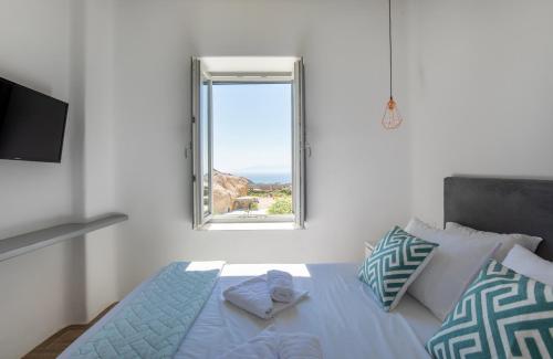 a bedroom with a bed with a window at Lectus Mykonos in Paraga