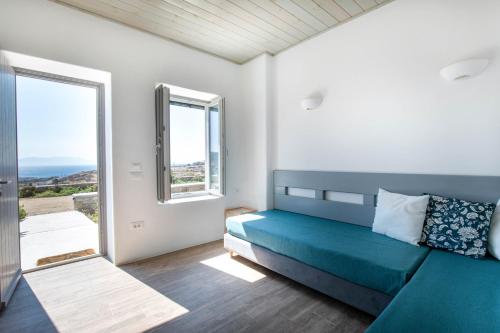 a bedroom with a bed and a large window at Lectus Mykonos in Paraga