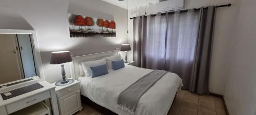 ein weißes Schlafzimmer mit einem Bett und einem Spiegel in der Unterkunft Sea's the Day in St Lucia