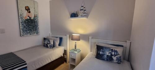 a small bedroom with two beds and a lamp at Sea's the Day in St Lucia
