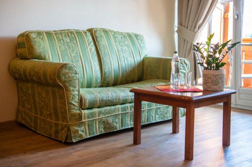 a living room with a green couch and a table at Sporthotel Radstadt in Radstadt