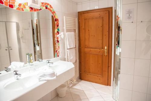 ein Badezimmer mit zwei Waschbecken und einem großen Spiegel in der Unterkunft Sporthotel Radstadt in Radstadt