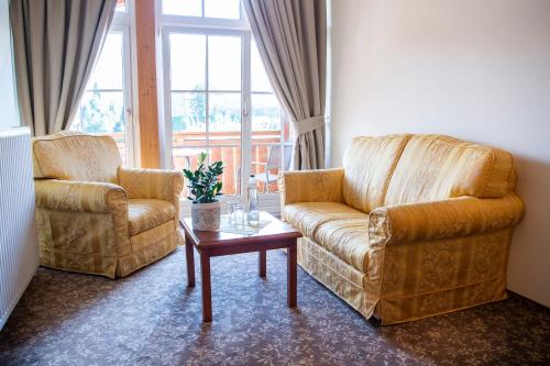 a living room with two chairs and a coffee table at Sporthotel Radstadt in Radstadt