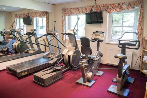 a gym with treadmills and ellipticals in a room at Sporthotel Radstadt in Radstadt