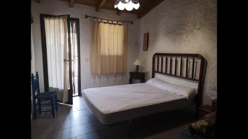 une chambre avec un lit, une chaise et une fenêtre dans l'établissement Rural House Mirador del Castillo, à Castillo