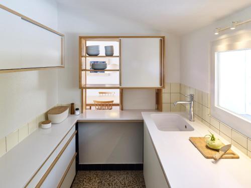 a white kitchen with a sink and a window at Adele (704 De) in Lenzerheide