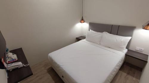 a bedroom with a large bed with white sheets and pillows at De Luna Hotel Sri Petaling in Kuala Lumpur