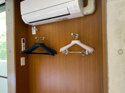 a bathroom with two hangers and a air conditioner at Mon Refuge Prive 屋上露天風呂のある隠れ家 in Motobu