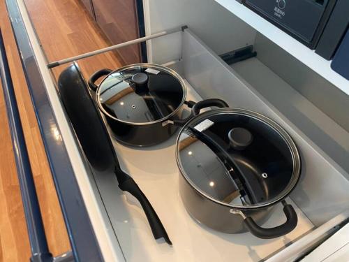 two pans sitting on top of a kitchen stove at Mon Refuge Prive 屋上露天風呂のある隠れ家 in Motobu