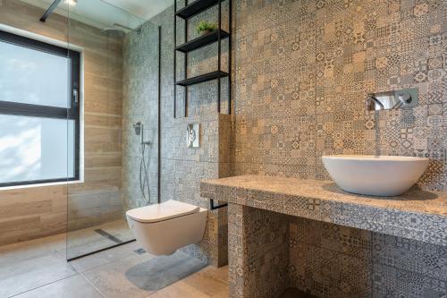 a bathroom with a toilet and a sink and a shower at Ktima Agrapidos - Grandpa Villa in Póros Kefalonias