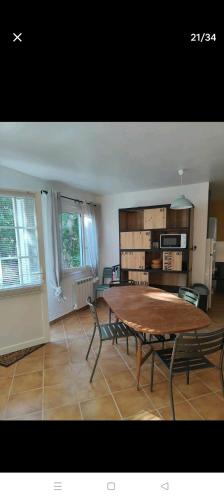 un salon avec une table et des chaises en bois dans l'établissement maison dans un écrin de chênes provençale, à Saint-Maurice-sur-Eygues
