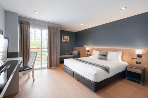バンコクにあるiCheck inn Residences Sathornのベッドとテレビが備わるホテルルームです。