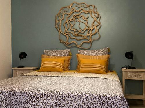 una camera da letto con un grande letto con cuscini gialli di La Petite Porte a La Saline Le Bains