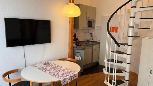 a small room with a table and a tv on a wall at Apartmenthaus Somborn in Bochum