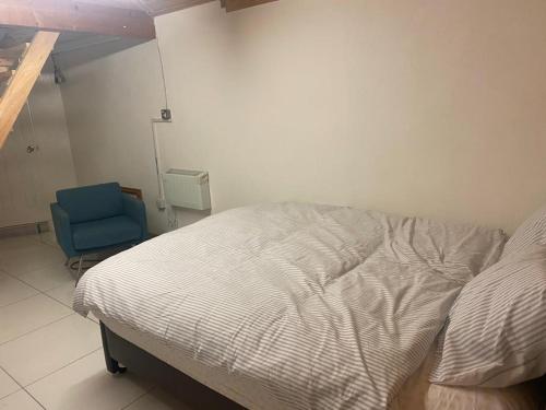 ein Schlafzimmer mit einem Bett und einem blauen Stuhl in der Unterkunft Parkview in Hoo