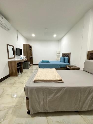 a large room with two beds and a tv at MGH Alona Resort in Panglao