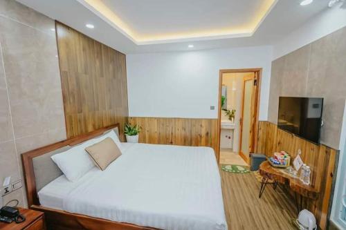 a bedroom with a large white bed and a television at Thung Lũng Kim Khuê Villas in Da Lat