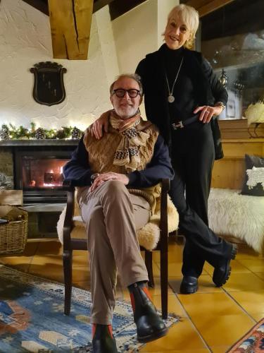 a woman standing next to a man sitting in a chair at Hotel Dente Del Gigante in Courmayeur