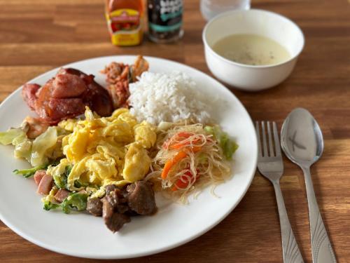 a plate of food with rice and a bowl of soup at MGH Alona Resort in Panglao