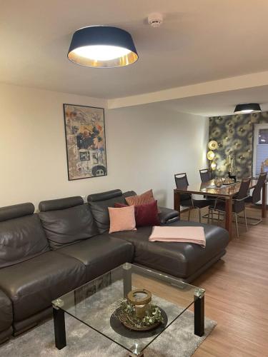 ein Wohnzimmer mit einem Ledersofa und einem Tisch in der Unterkunft Gemütliche Ferienwohnung in Wernigerode