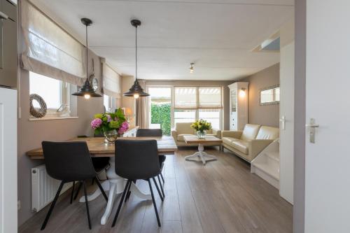 a dining room and living room with a table and chairs at Vakantiewoning Domburg dichtbij strand, Kanonweistraat 12a in Domburg