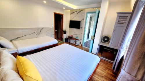 a hotel room with two beds and a couch at Thung Lũng Kim Khuê Villas in Da Lat