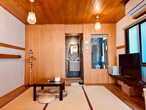 un salon avec une table et une télévision dans l'établissement 末廣通二館 日式包棟民宿Suehirodori Japanese Entire Homes No2, à Tainan
