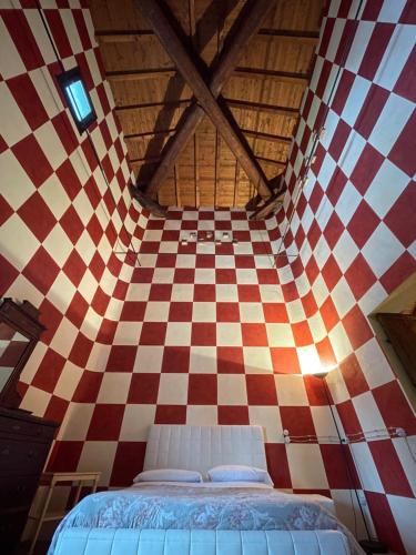 1 dormitorio con una pared de cuadros rojo y blanco en Agriturismo Corte Spino, en Nogarole Rocca