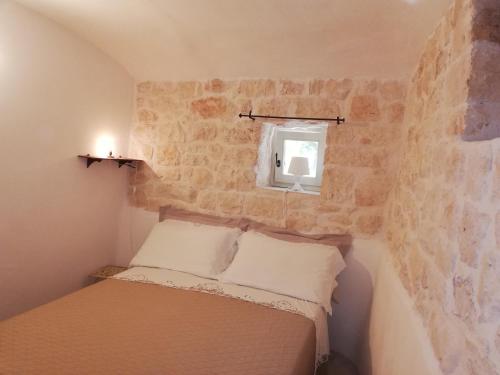 mała sypialnia z łóżkiem i oknem w obiekcie B&B Giovannarolla Green House w mieście Ostuni
