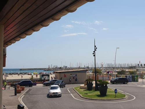 parking z samochodami zaparkowanymi na parkingu w pobliżu plaży w obiekcie Studio neuf atypique centre ville Palavas vue mer w mieście Palavas-les-Flots