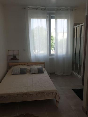 une chambre avec un grand lit avec deux fenêtres dans l'établissement Studio neuf atypique centre ville Palavas vue mer, à Palavas-les-Flots