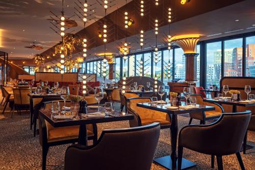 a restaurant with tables and chairs and large windows at Hyatt Regency Dusseldorf in Düsseldorf