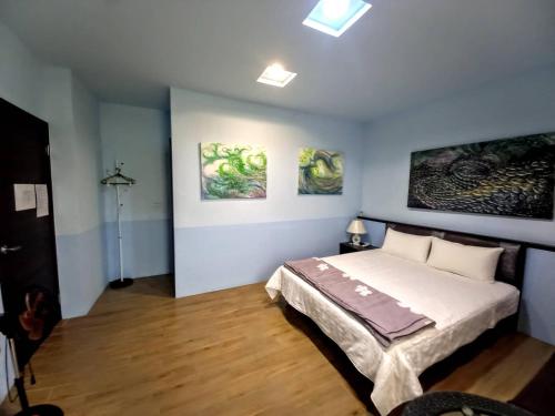 馬公市的住宿－愛上水漾魚夢民宿，卧室配有一张床,墙上挂有绘画作品