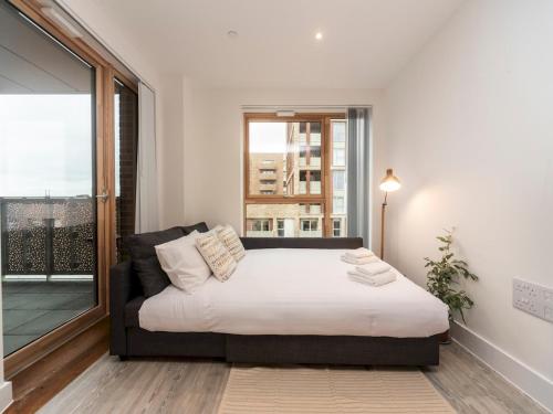 1 dormitorio con cama y ventana grande en Pass the Keys Spacious Bright Flat 20 Mins To Central London, en Londres