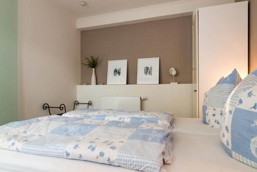 Un dormitorio con una cama con sábanas azules y blancas. en Meer Residenz Warnemuende, en Warnemünde